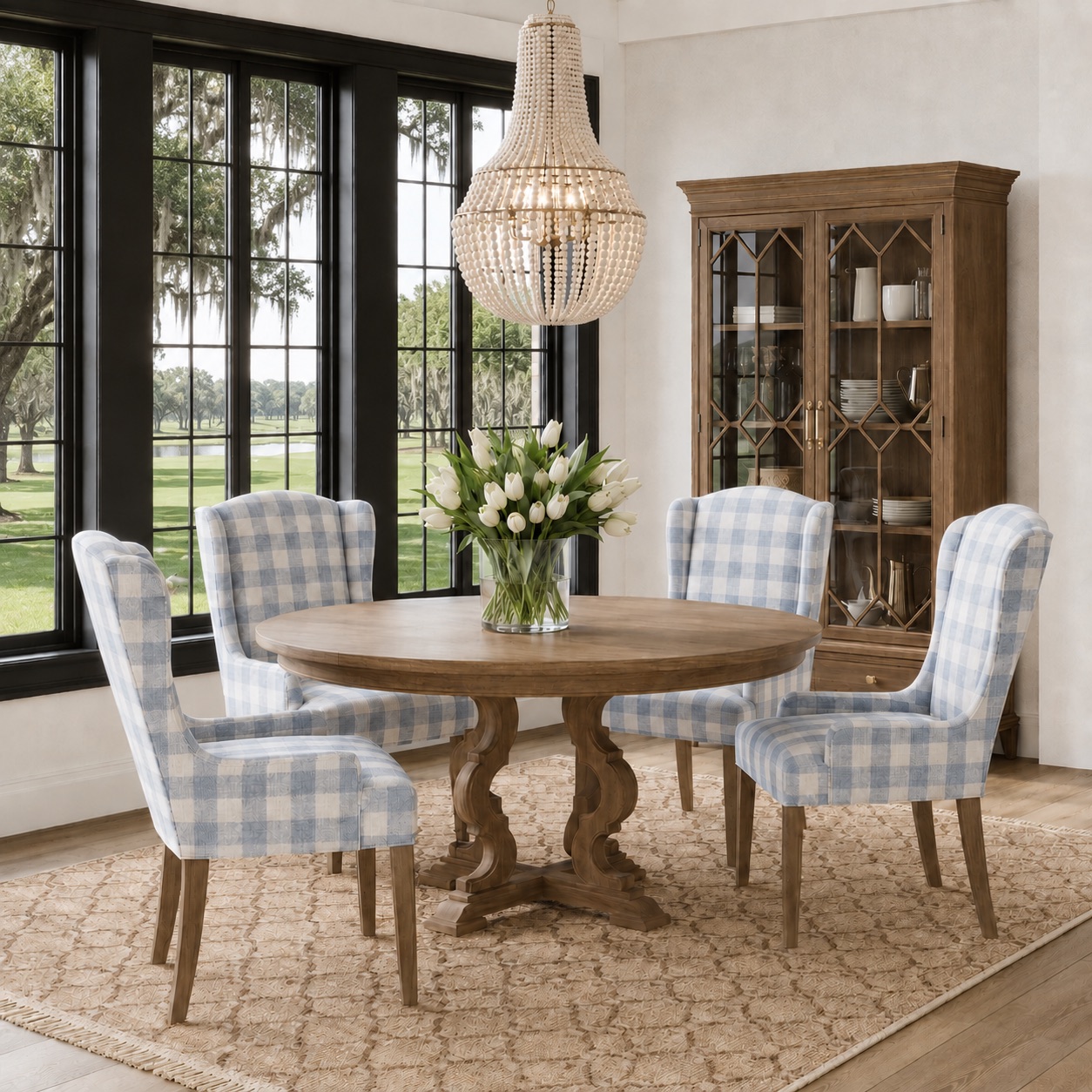 Rendered dining room with blue gingham wing chairs, round oak table, and beaded chandelier