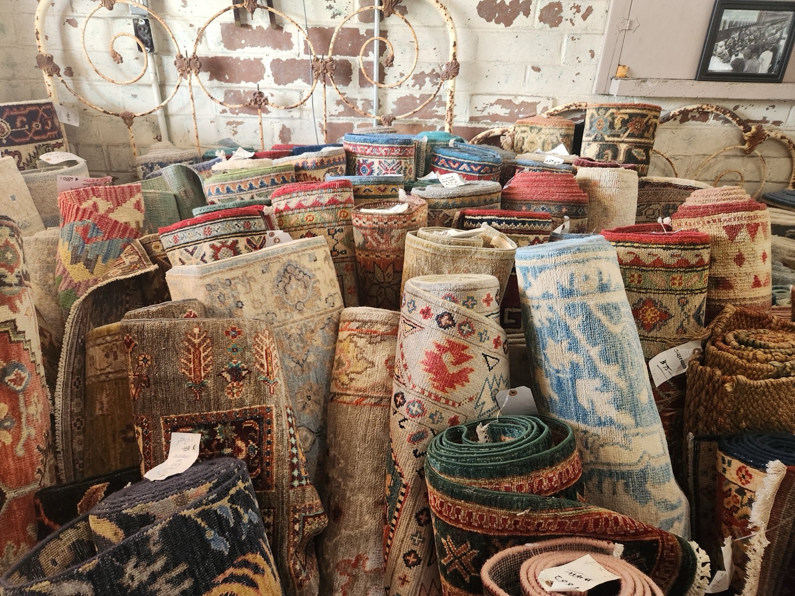 Rolled traditional rugs stacked inside the historic Yemassee train depot at Fletcher's Rug Company