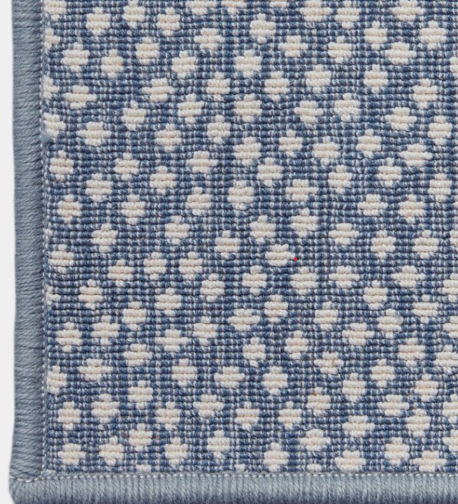 A close-up of a blue and cream spotted rug, similar to the looped construction Kary chose for her dining room
